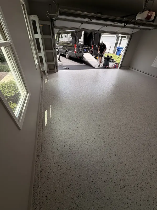 Finished garage floor with the van parked outside the open door
