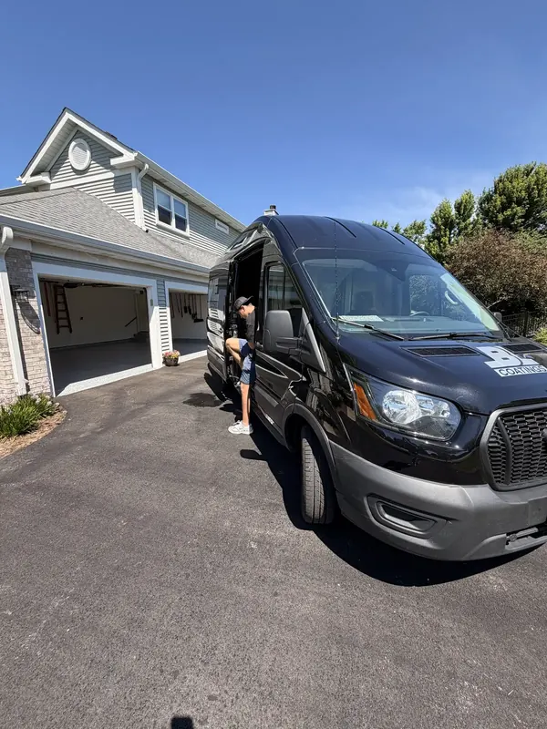Work van parked in a driveway outside an open garage