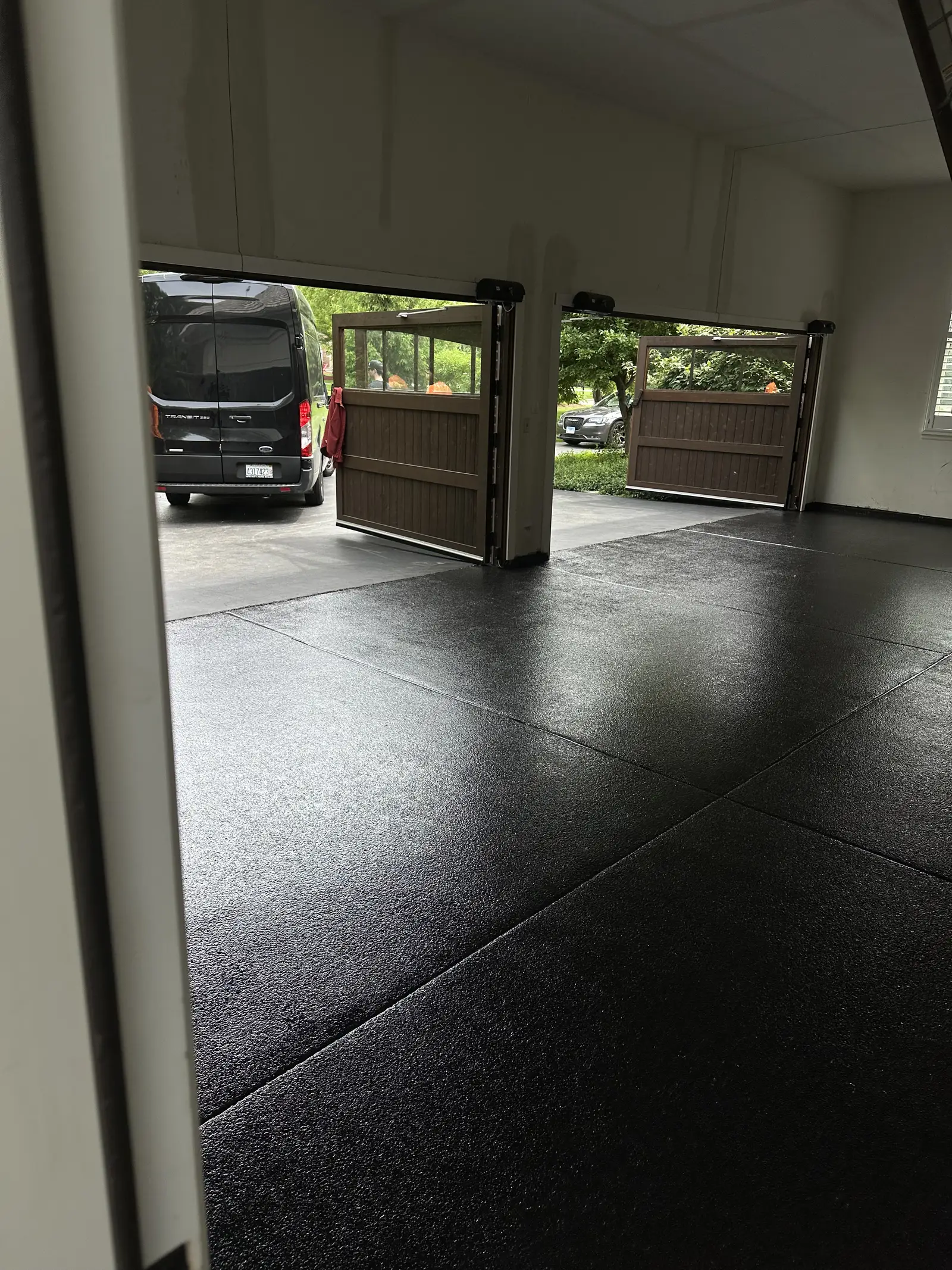 Black flake coated garage floor seen through open garage doors