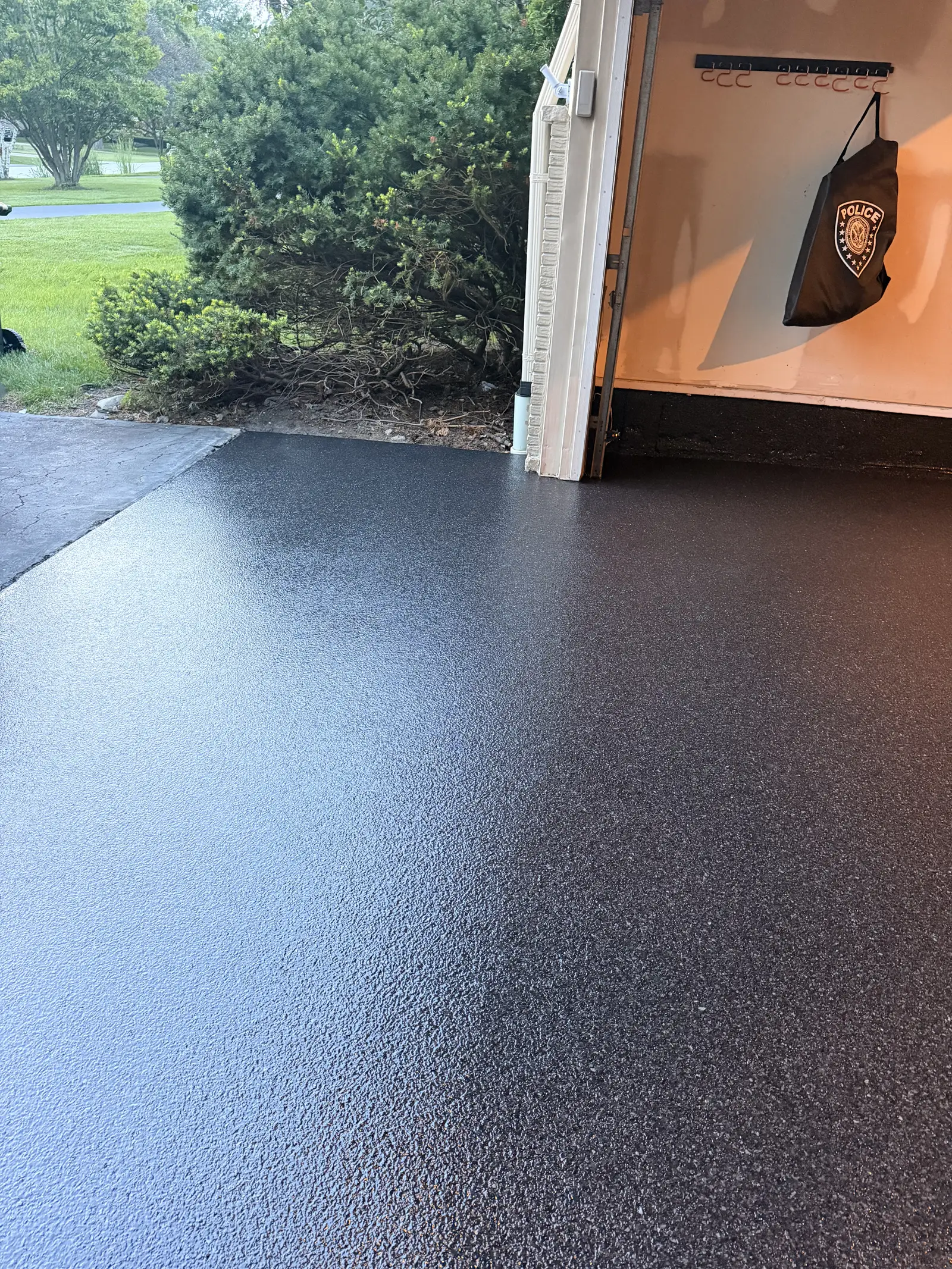 Black flake coated garage floor running out to an open garage door