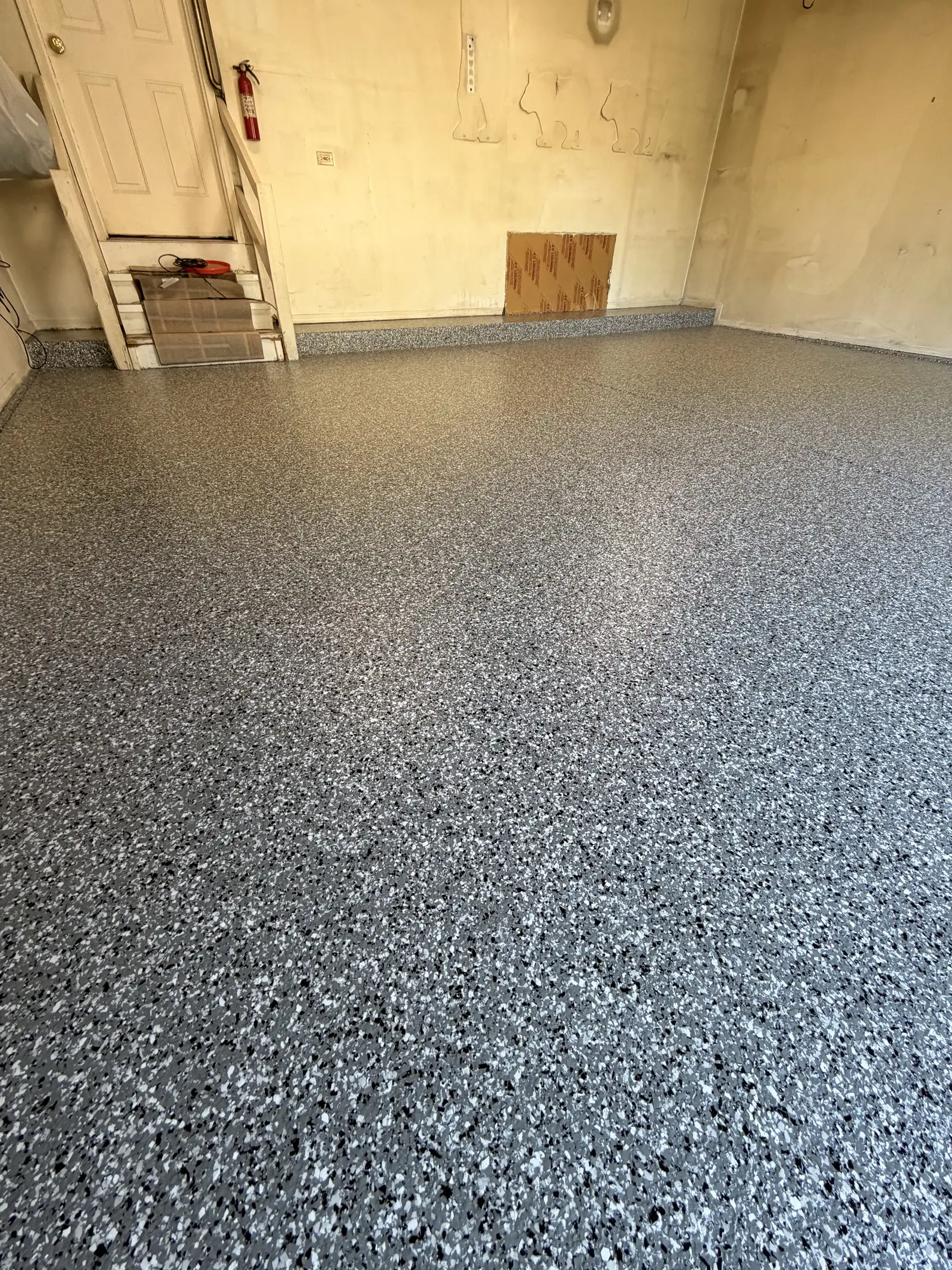 Close detail of a grey and white flake floor under a clear topcoat
