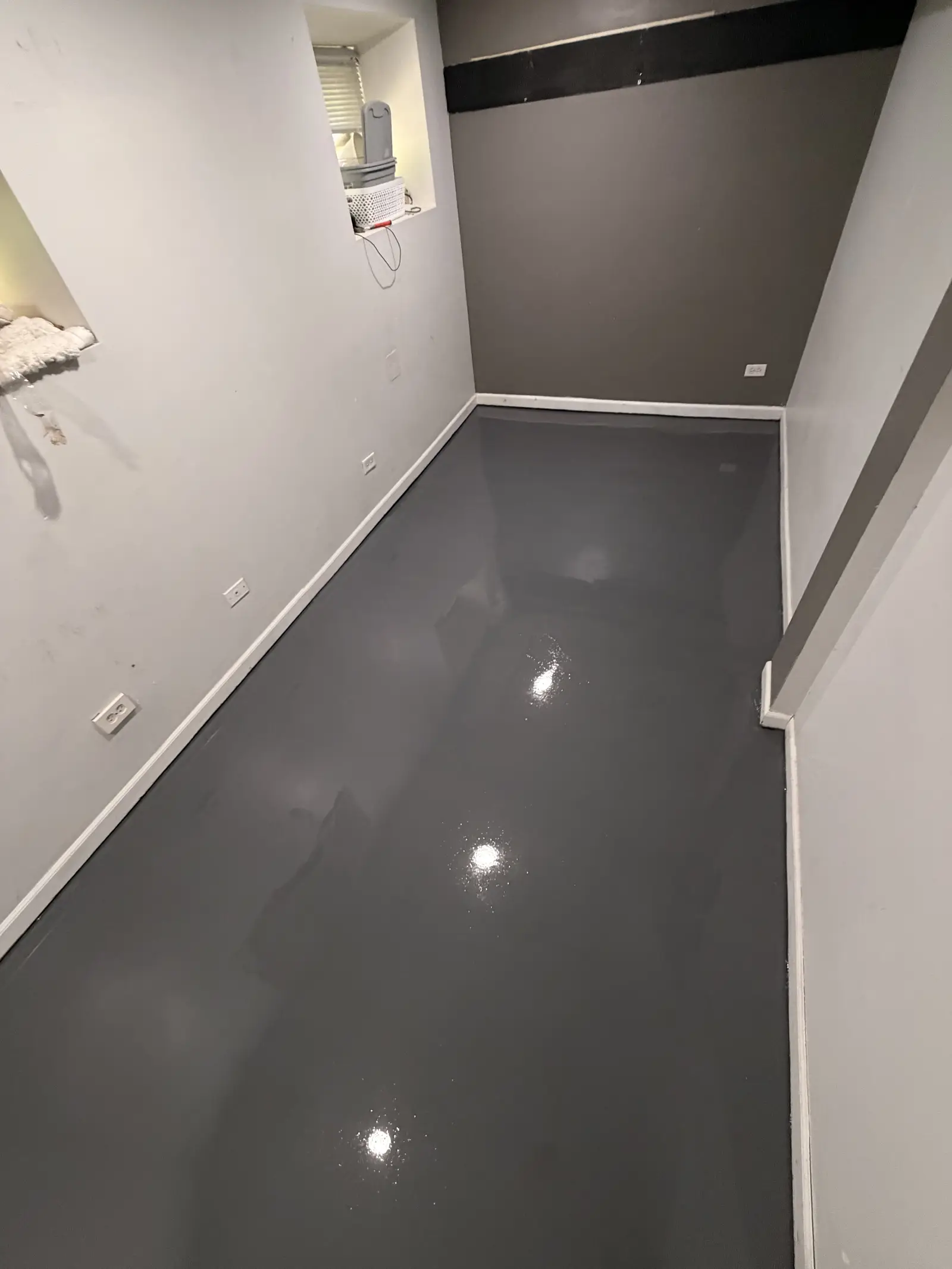 Solid grey metallic floor finished to a mirror gloss in a basement room