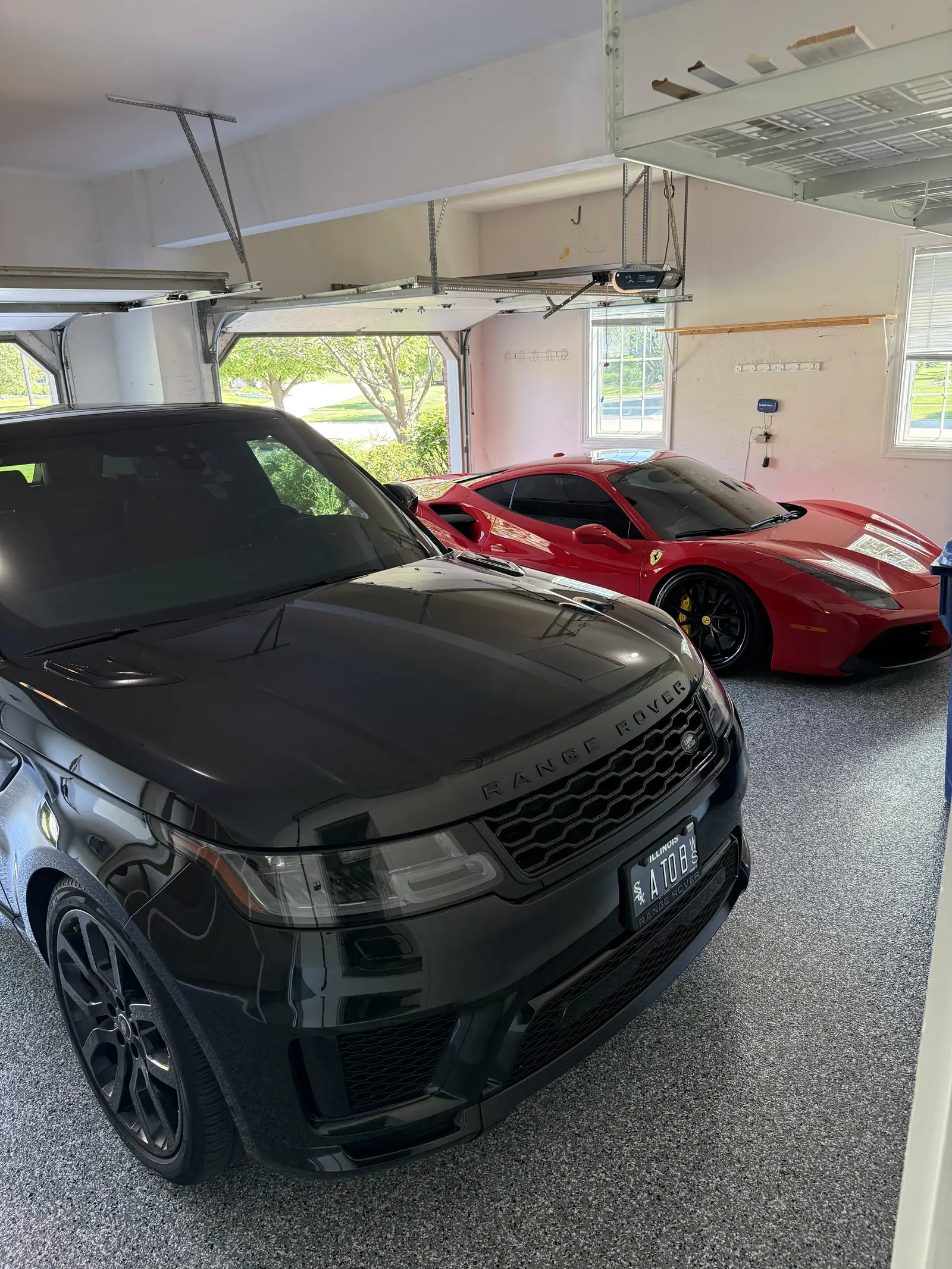 Range Rover and a red Ferrari parked on a flake coated garage floor